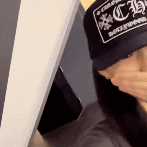 a person wearing a hat that says chrome hearts