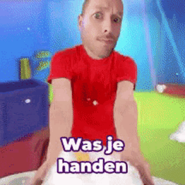 a man in a red shirt with the words was je handen written on it
