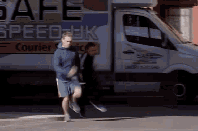 a man running in front of a safe speed uk courier truck