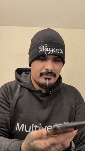 a man wearing a black beanie and a black multiverse hoodie