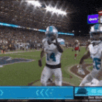 a football game is being played in a stadium and the players are wearing white and blue uniforms