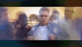 a man is standing in front of a crowd of people with his mouth open .