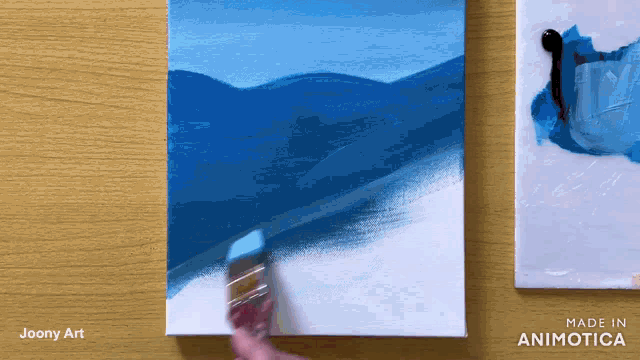 a painting is being painted on a wooden table with the words made in animatica on the bottom