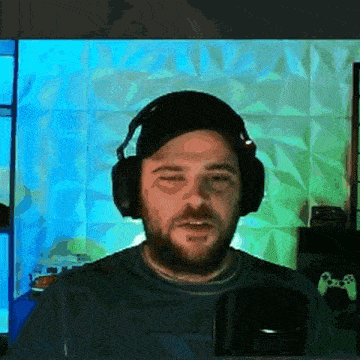 a man wearing headphones and a baseball cap looks at the camera