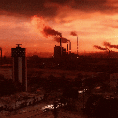 a factory with smoke coming out of the chimneys at night