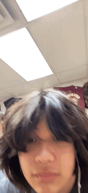 a person 's head is visible in front of a ceiling light and a shirt that says ' texas tech ' on it