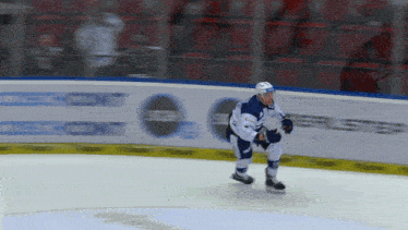a hockey player is skating on the ice in front of a sign that says " ccm "