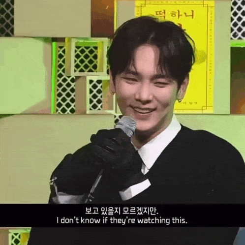a man holding a microphone with the words i don 't know if they 're watching this on the bottom
