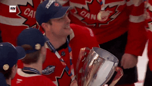a man holding a trophy with the letter c on his shirt