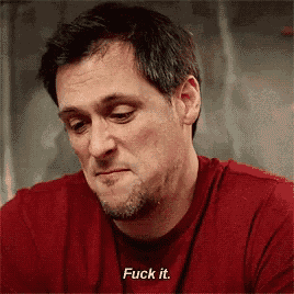 a man wearing a red shirt is saying fuck it .