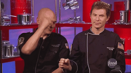 two men in chef 's uniforms are standing next to each other in front of a food network logo .