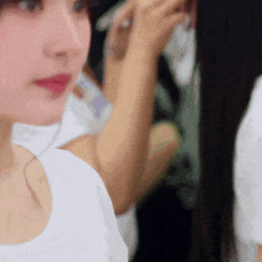 a close up of a woman 's face in a white shirt