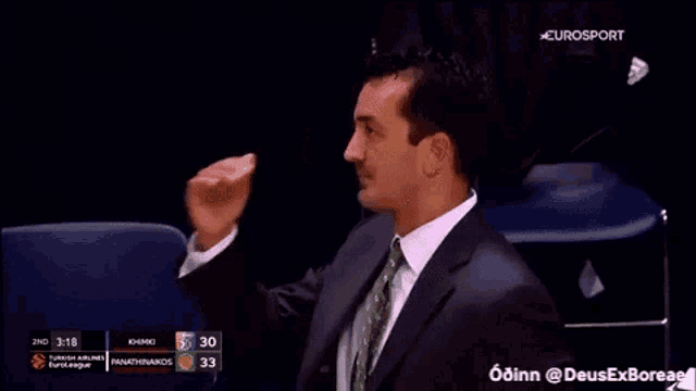 a man in a suit and tie is giving a thumbs up during a basketball game on eurosport