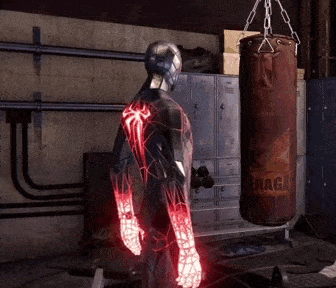 a man in a spiderman suit is standing in front of a punching bag that says ' snaga ' on it