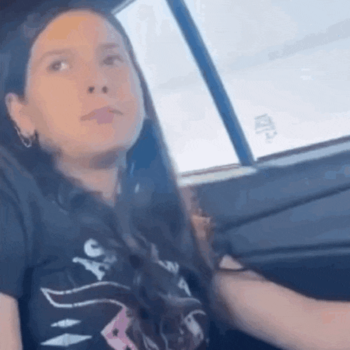 a woman is sitting in the driver 's seat of a car .