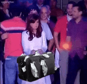 a woman holding a suitcase full of money in front of a crowd of people
