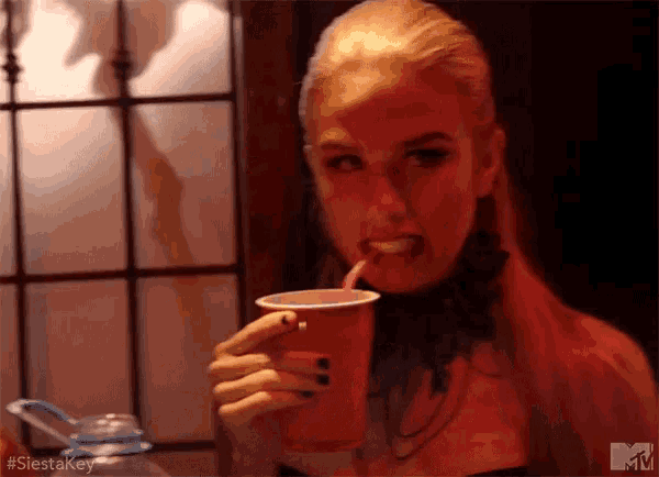 a woman is drinking from a red cup with a straw and the hashtag #siestakey