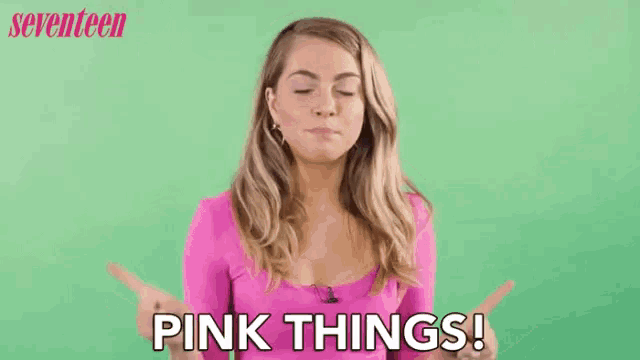 a woman in a pink shirt is pointing at something and saying pink things .