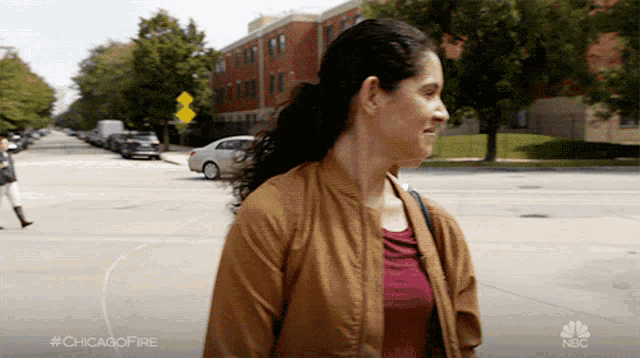 a woman walking down a street with #chicagofire written on the bottom right