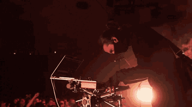 a man is playing a keyboard in a dark room