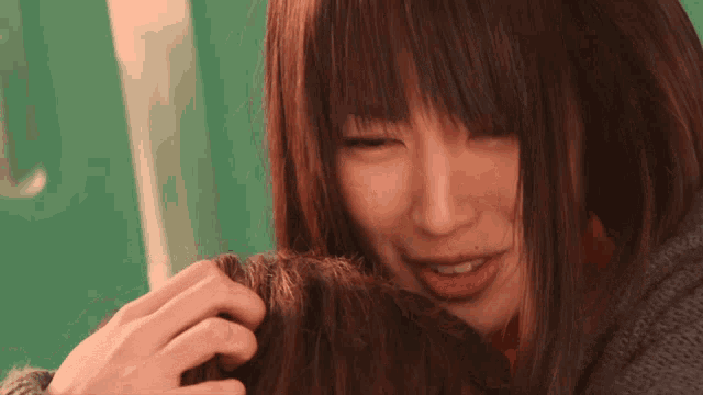 a close up of a woman 's face with a gray sweater on
