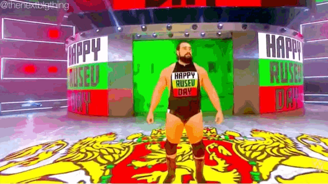 a wrestler is standing on a stage wearing a shirt that says happy russian day .