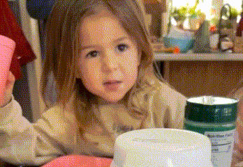 a little girl looking at a container with a nutrition facts label
