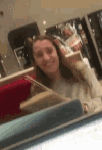 a woman is smiling in front of a mirror