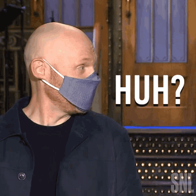 a man wearing a face mask says huh in front of a door