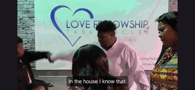 a man is standing next to a woman in front of a sign that says love fellowship