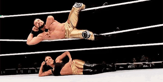 a man and a woman are wrestling in a ring and the man is wearing gold pants