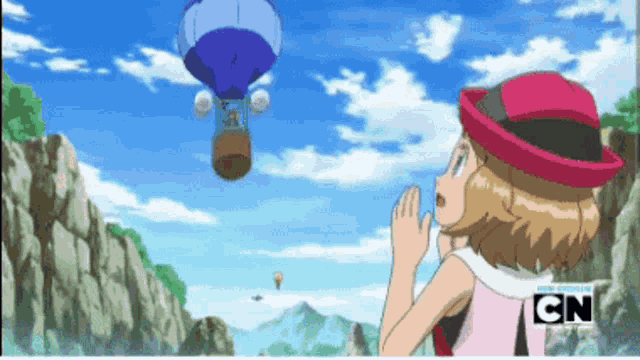 a girl in a pink hat looks at a hot air balloon in the sky with cn written on the bottom