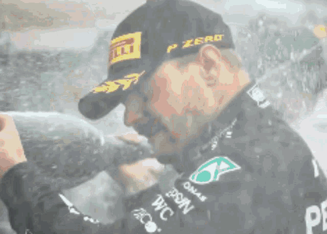 a man wearing a hat that says p zero is drinking from a bottle