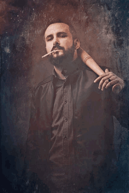 a man with a beard is smoking a cigarette while holding a bat on his shoulder