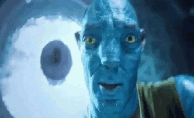 a close up of a man with a blue face and yellow eyes looking at the camera .