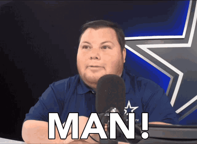 a man sitting in front of a microphone with the word man written on his face