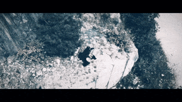 an aerial view of a person on a rocky cliff