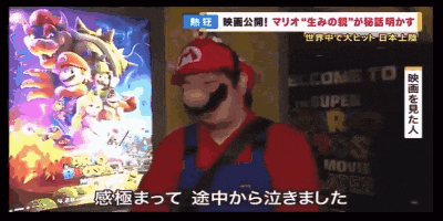 a man in a mario costume stands in front of a sign that says welcome to the super mario movie theater