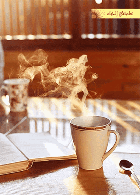 a cup of coffee with steam coming out of it is on a table next to an open book
