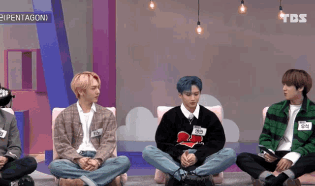 a group of young men are sitting in a room with tbs written on the bottom of the screen