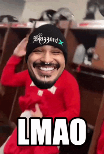 a man wearing a beanie with the word blazzard on it is smiling
