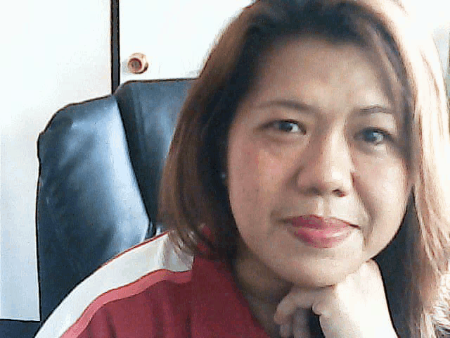 a woman with her hand on her chin is wearing a red shirt