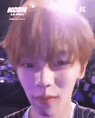 a close up of a person 's face with the words kcon la 2024 on the bottom right