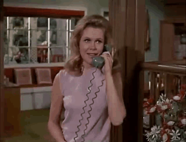 a woman is talking on a telephone in a room .