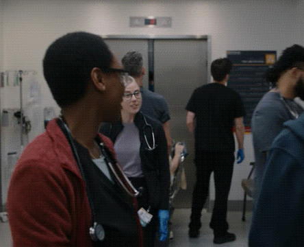 a woman with a stethoscope around her neck is standing in a hospital room with other people