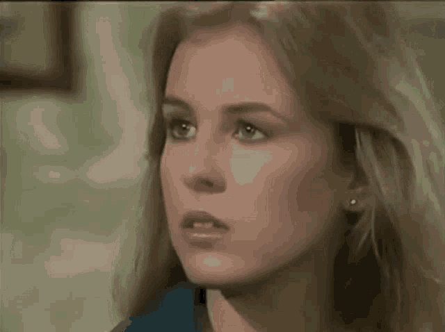 a close up of a woman 's face with a blue shirt on .