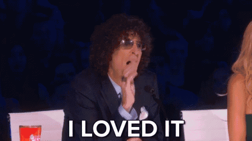 a man with curly hair is sitting in front of a microphone with the words i loved it behind him