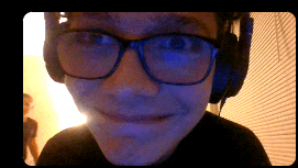 a man wearing headphones and glasses is smiling