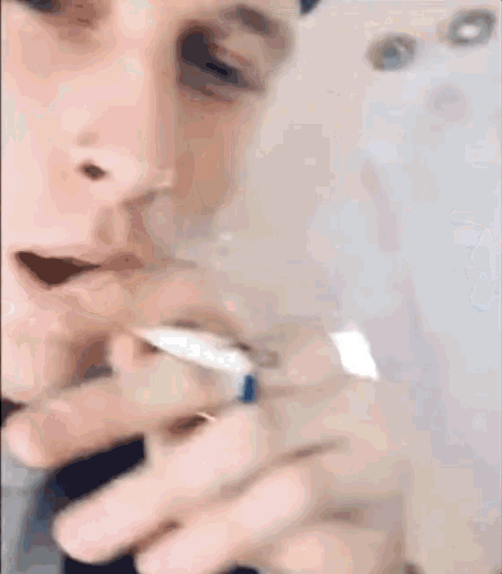 a man is smoking a cigarette on a plane while wearing a blue ring