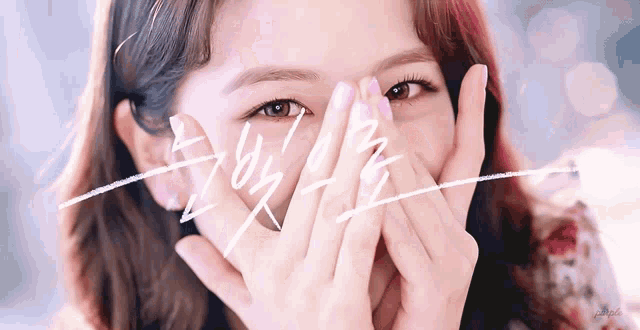 a close up of a woman covering her face with her hands in front of a sign that says ' i love you '